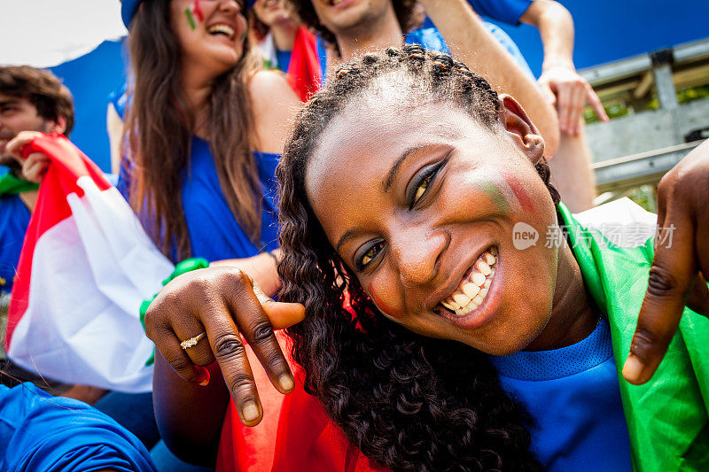 微笑欢呼的黑人妇女和意大利足球队的支持者