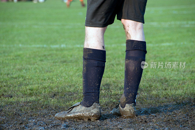 穿着沾满泥的鞋子和衣服的足球运动员