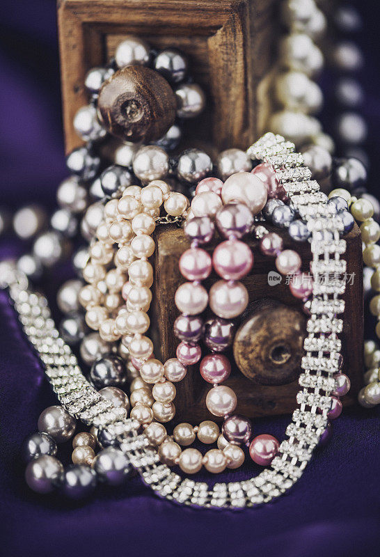 钻石和珍珠珠宝收集在丰富的紫色缎子