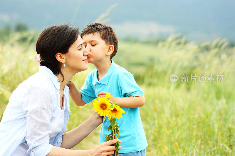 小男孩送花并亲吻妈妈