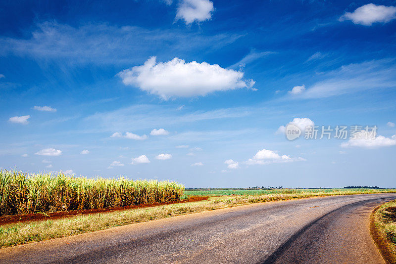 古巴的乡村公路，田野和多云的天空