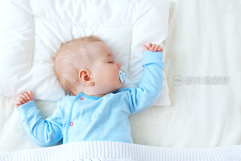 婴儿睡在蓝色的毯子上