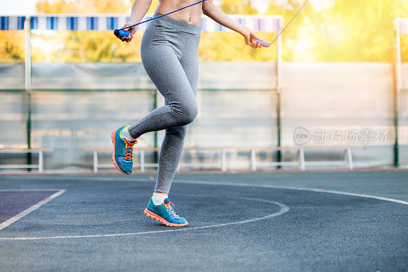 年轻女子运动员在体育场上跳绳训练的低段
