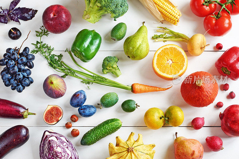 俯视图彩虹色的水果和蔬菜在一个白色的桌子上。