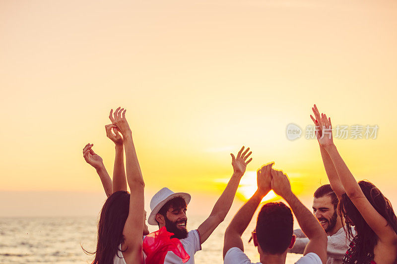 人们举起手在海滩上跳舞。关于派对、音乐和人的概念