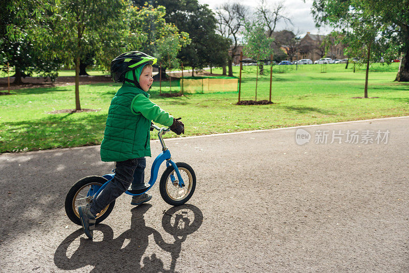 可爱的微笑小男孩骑着平衡自行车