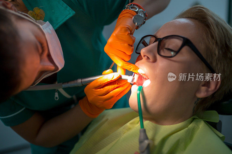 牙医在牙科医生那里检查病人的牙齿。