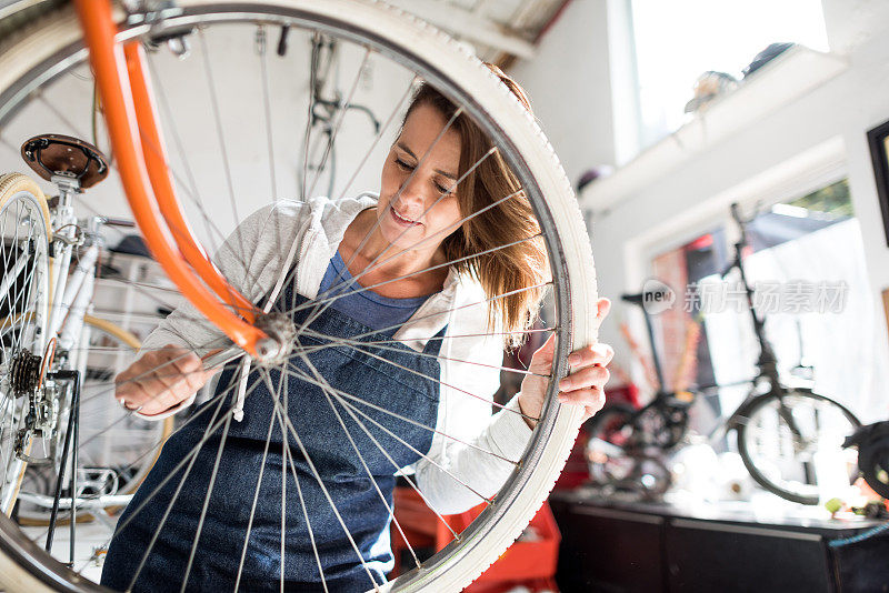 女性在自行车修理店修理自行车微笑