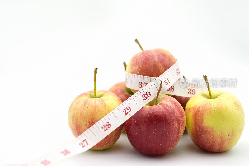 食品与健康概念。用卷尺拉近苹果。