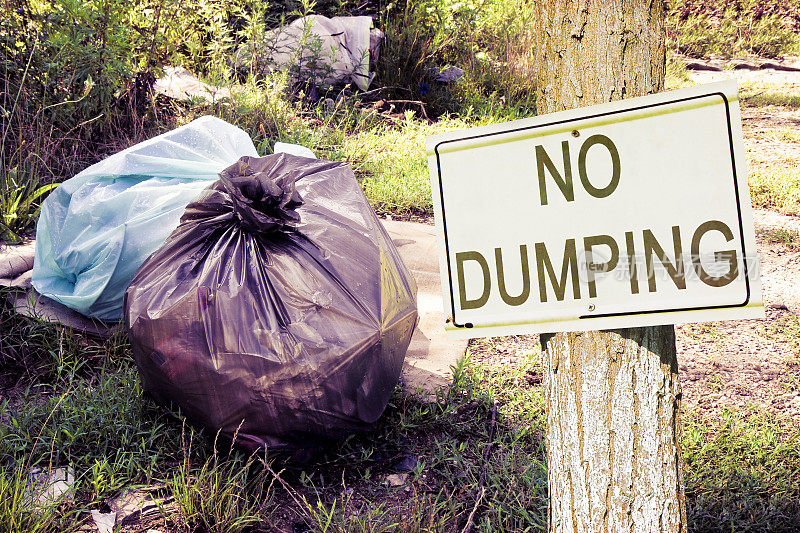 在野外非法倾倒垃圾，并在郊野标明“禁止倾倒”标志-概念形象