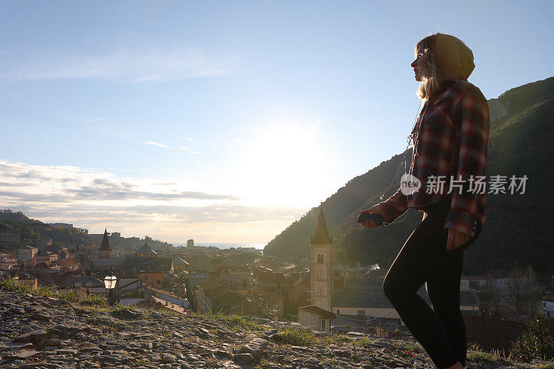 日出时，年轻女子在村庄和海面上行走