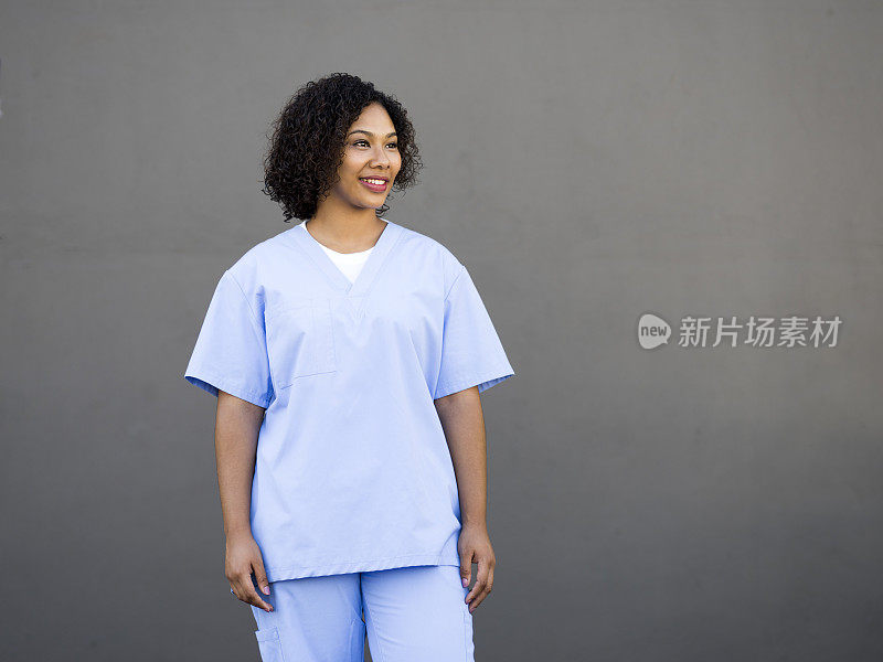 微笑的护士靠墙站在医院