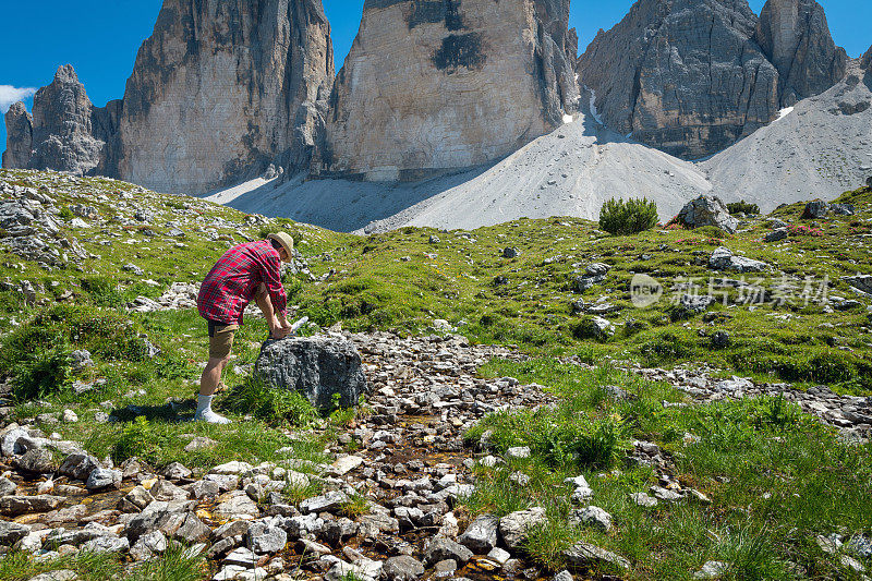 在意大利阿尔卑斯山白云石区的拉瓦雷多广场徒步旅行时，一位老人正在穿鞋
