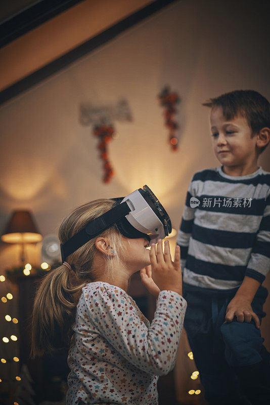 在舒适的圣诞氛围中，孩子们在客厅玩VR眼镜