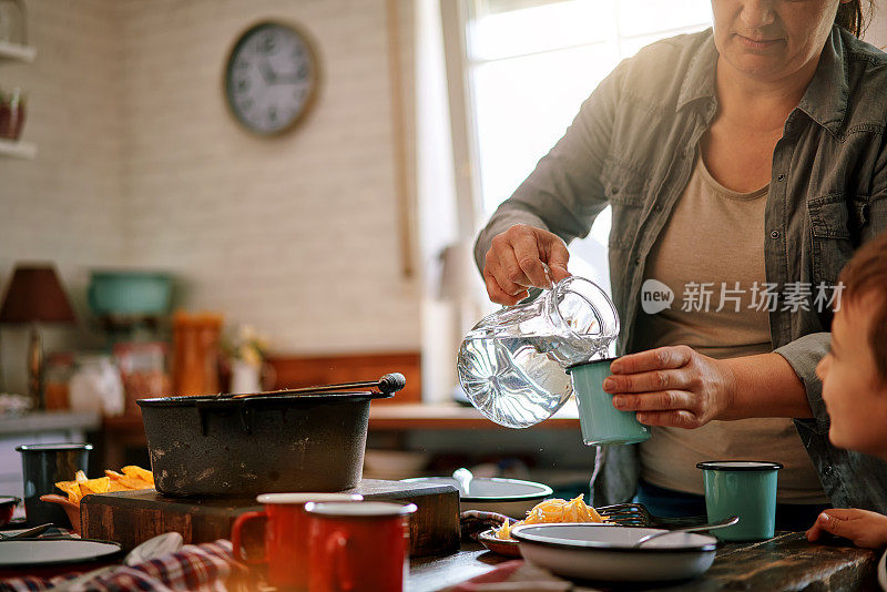 年轻的家庭在家庭厨房里吃辣肉酱