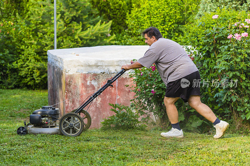 拿着割草机的人