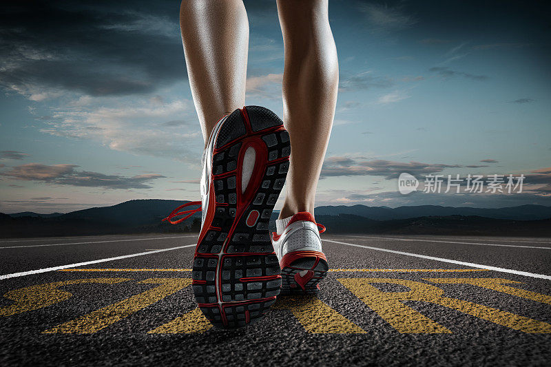 近距离的女人的脚跑和训练在跑道上与字开始