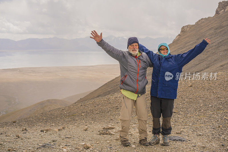 在中国和吉尔吉斯斯坦边境附近4000米高的山口，徒步旅行者，年长的男女举起了手