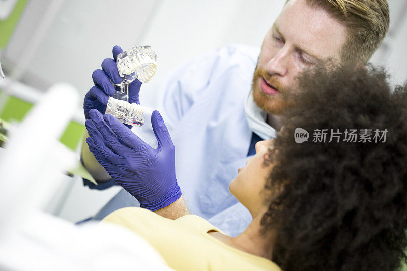 正牙医师向病人展示一套牙齿模型