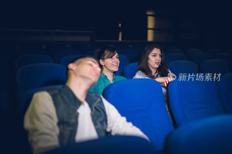 三个朋友在电影院看电影，其中一个在睡觉
