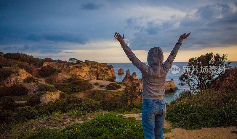 年轻的黑发女性享受她的自由在阿尔沃葡萄牙海滩在夏末的太阳