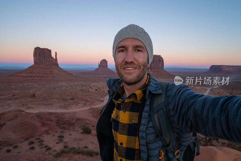 一名在美国旅行的年轻人在日落时分的纪念碑谷拍摄自拍照