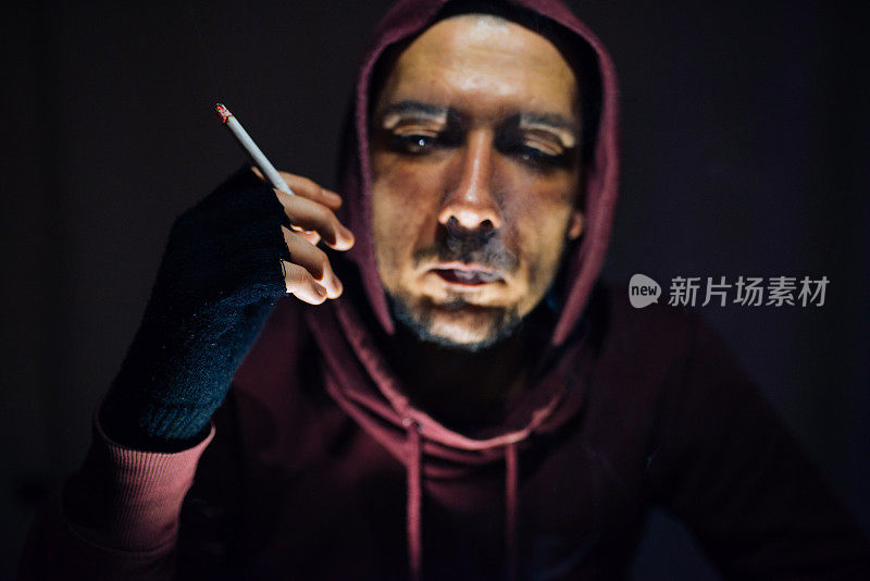 穿着帽衫和黑手套的大胡子黑客的肖像