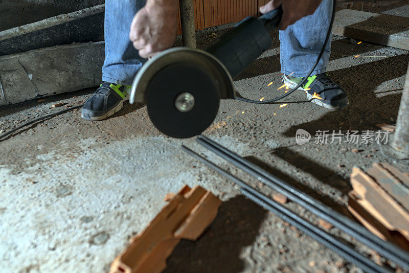 建筑工人正用金属磨床在建筑工地工作