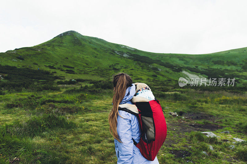 女人和狗在背包里登山