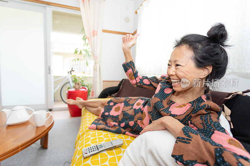 坐在沙发上看电视的女人