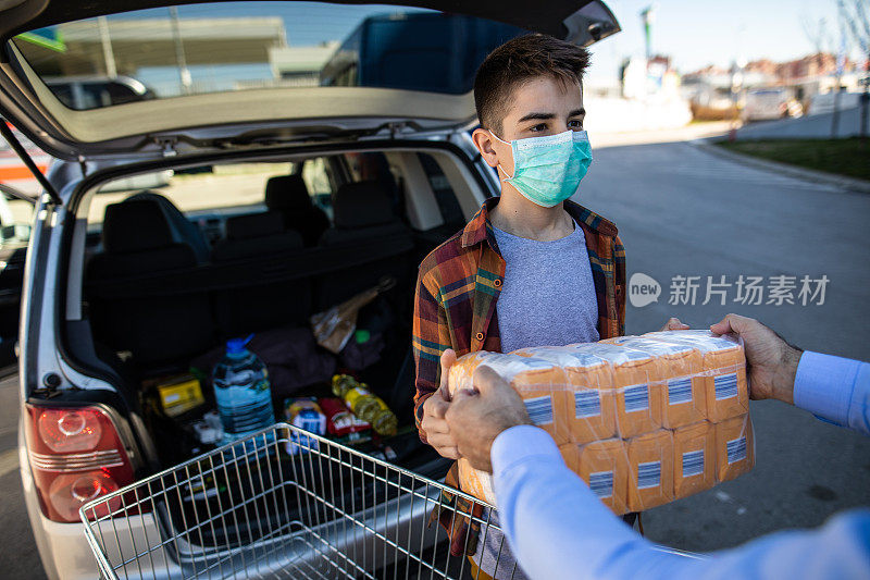 在病毒流行的时刻，一个十几岁的男孩帮助父亲在汽车后备箱里装面粉