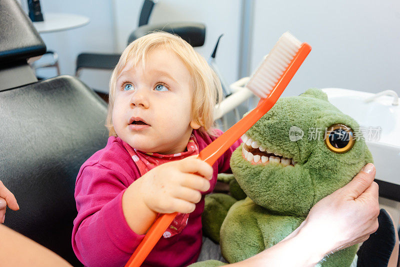 孩子在牙医面前刷着毛绒玩具