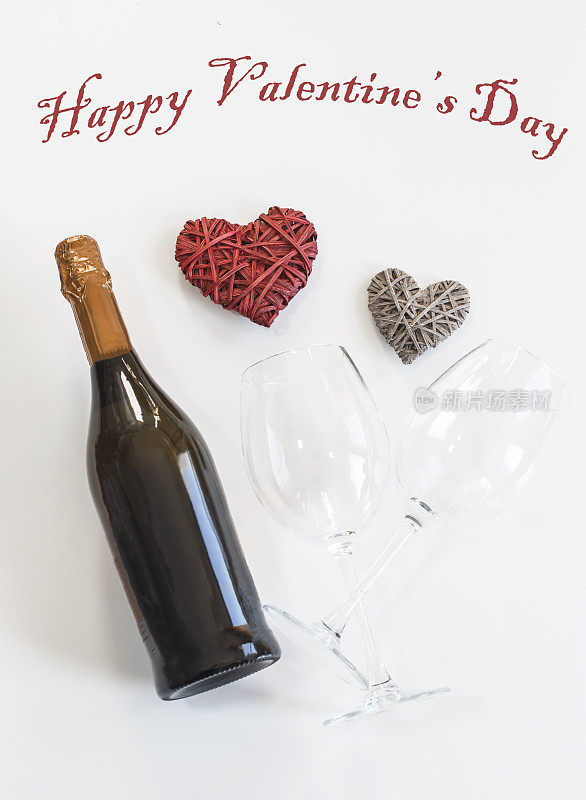 情人节贺卡与香槟酒瓶和玻璃杯在白色木板。前视图。短信情人节快乐