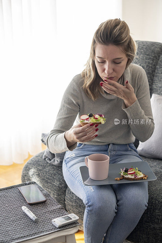 年轻的糖尿病妇女在家吃早餐