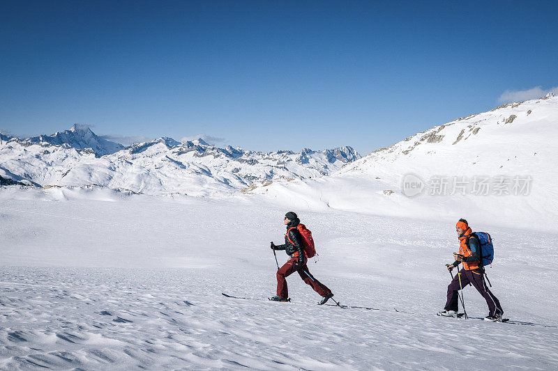 滑雪登山运动员攀登积雪的山脊线