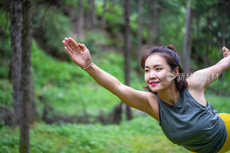 年轻的亚洲女人在森林里练习瑜伽