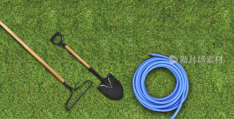 园艺工具，软管，铲和耙在草地上