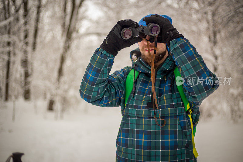 年轻英俊的男子在滑雪运动服山和看别处