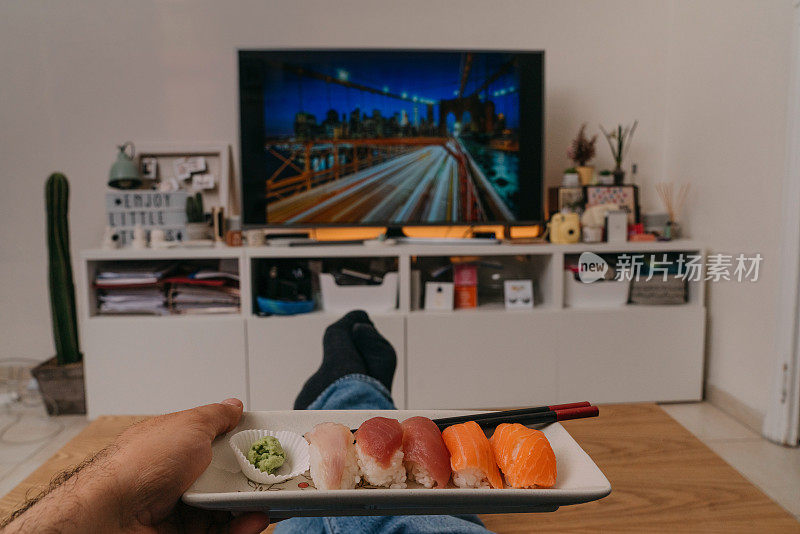 男人一边吃寿司一边看电视电影