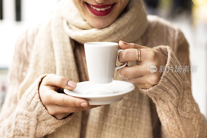 咖啡杯，女士的手拿着咖啡杯，女士拿着一个白色的杯子，白色的杯子里装着浓咖啡，