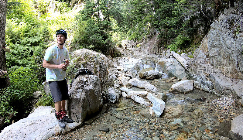 女山地自行车填满水瓶在高山溪流