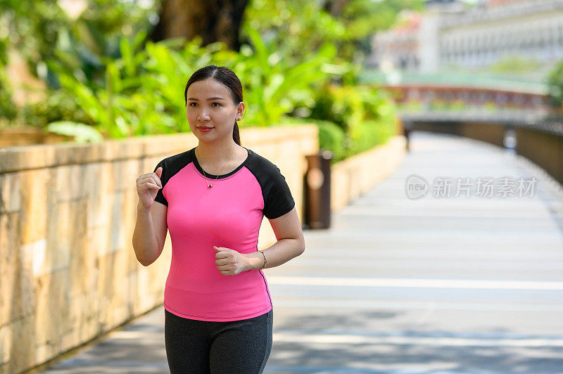 一位亚洲女运动员在城市公共公园慢跑