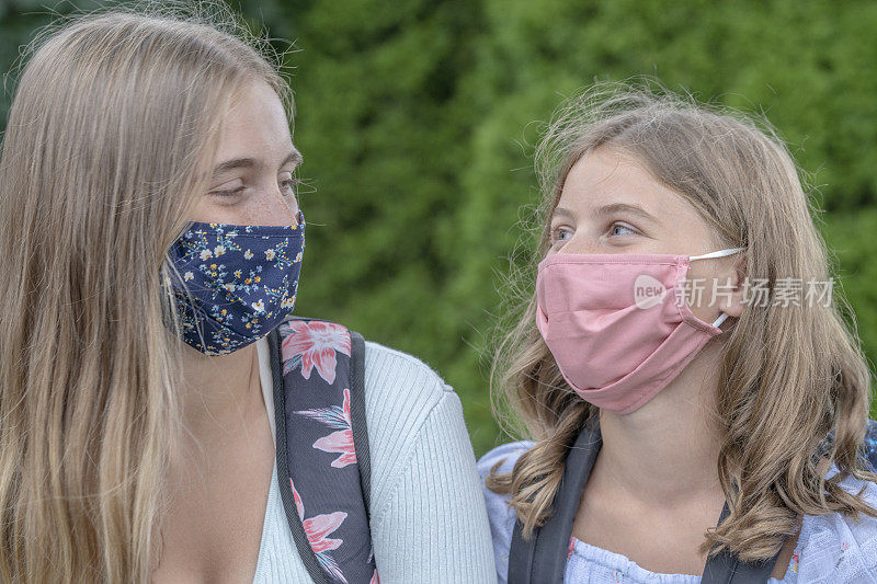 2019冠状病毒病后，姐妹们戴着口罩返回学校