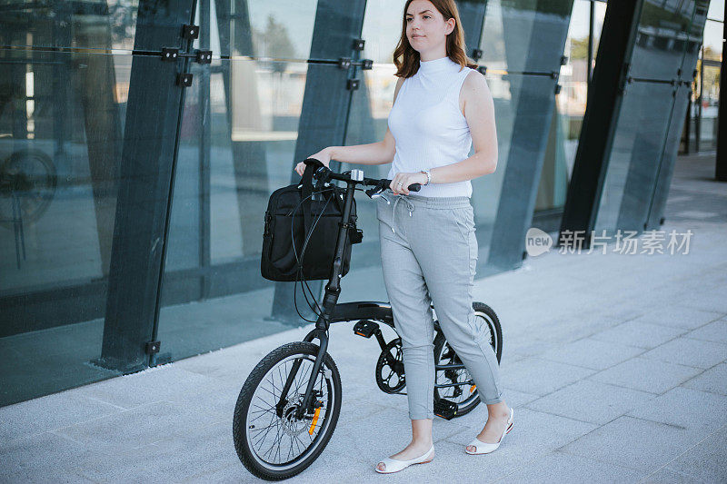 女商人带着她的折叠自行车去上班