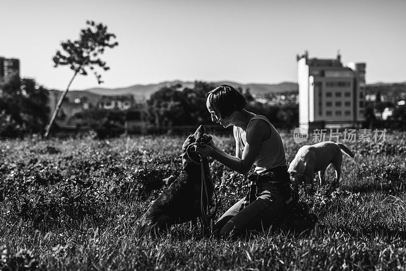 一个女人在公园里抱着她的狗