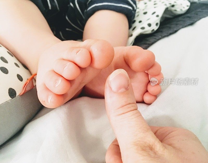 婴儿的脚和母亲的拇指