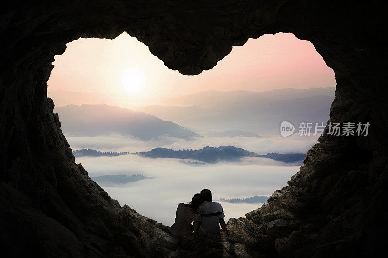 浪漫的情侣在山洞里欣赏山景