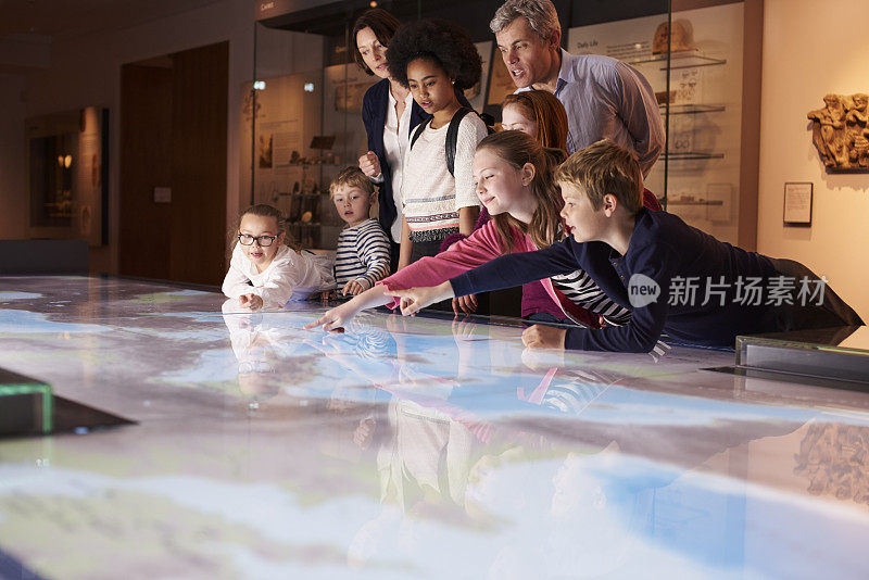 小学生在学校参观博物馆，看地图