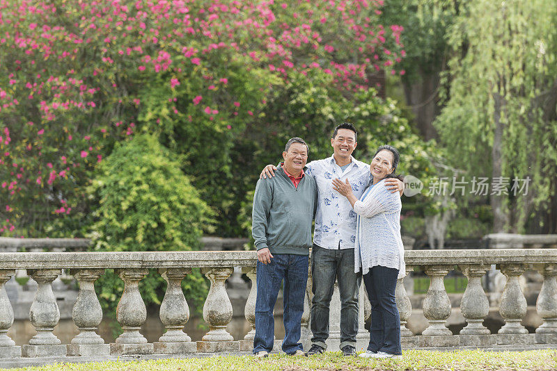 年老的亚洲夫妇和成年的儿子在公园