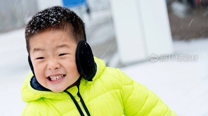 一个亚洲男孩在雪地里玩